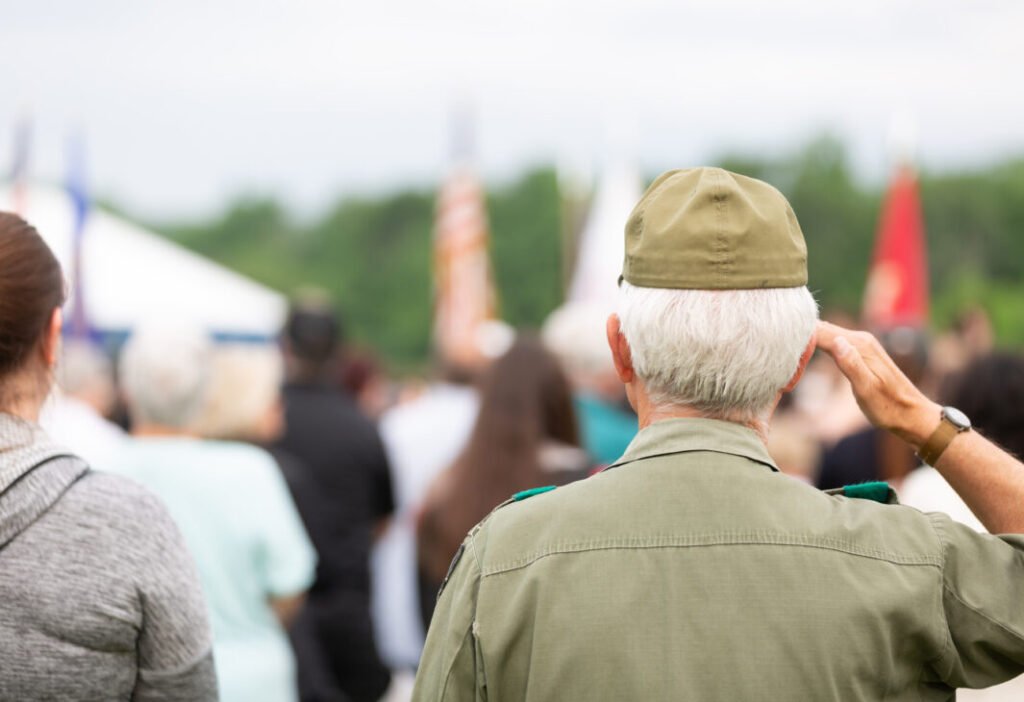 Veteran saluting flag at outdoor event